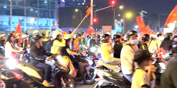 开云-越南民众深夜狂欢！美女球迷纯洁笑容 万人骑摩托+扛国旗涌上街头